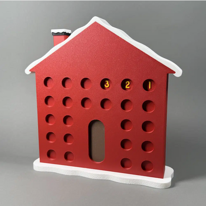 Red advent calendar in the shape of a house with a snowy roof
